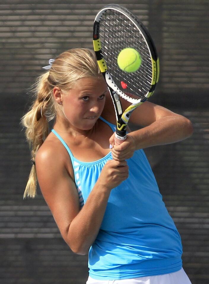 Corona del Mar High's Siena Sharf backhands the ball during a doubles match against Peninsula on Wednesday.