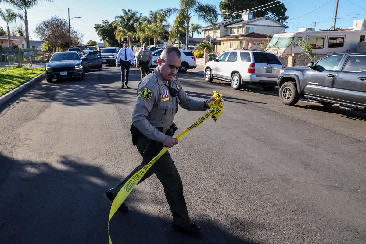 A police officer move crime scene tape