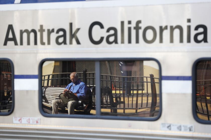 SAN DIEGO, CA - SEPTEMBER 16: Ralph Hammock waits for a coaster as he is reflected in the window of an Amtrak Pacific Surfliner train stopped at the Santa Fe Depot in San Diego due to rail closures along the coast in San Clemente on Thursday, Sept. 16, 2021. . (K.C. Alfred / The San Diego Union-Tribune)