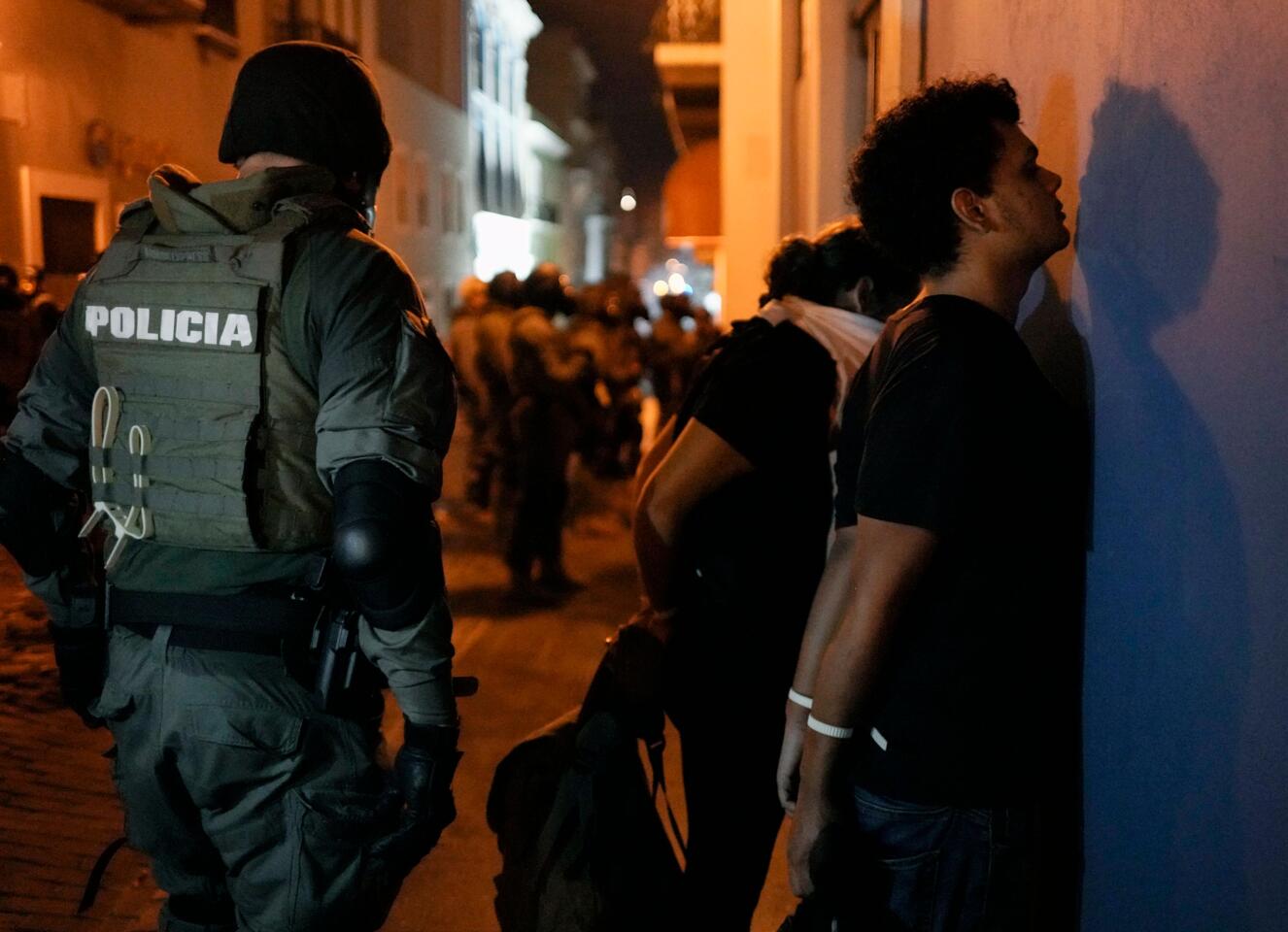 Protesters are detained by police in San Juan as thousands marched in Puerto Rico for a fifth day.
