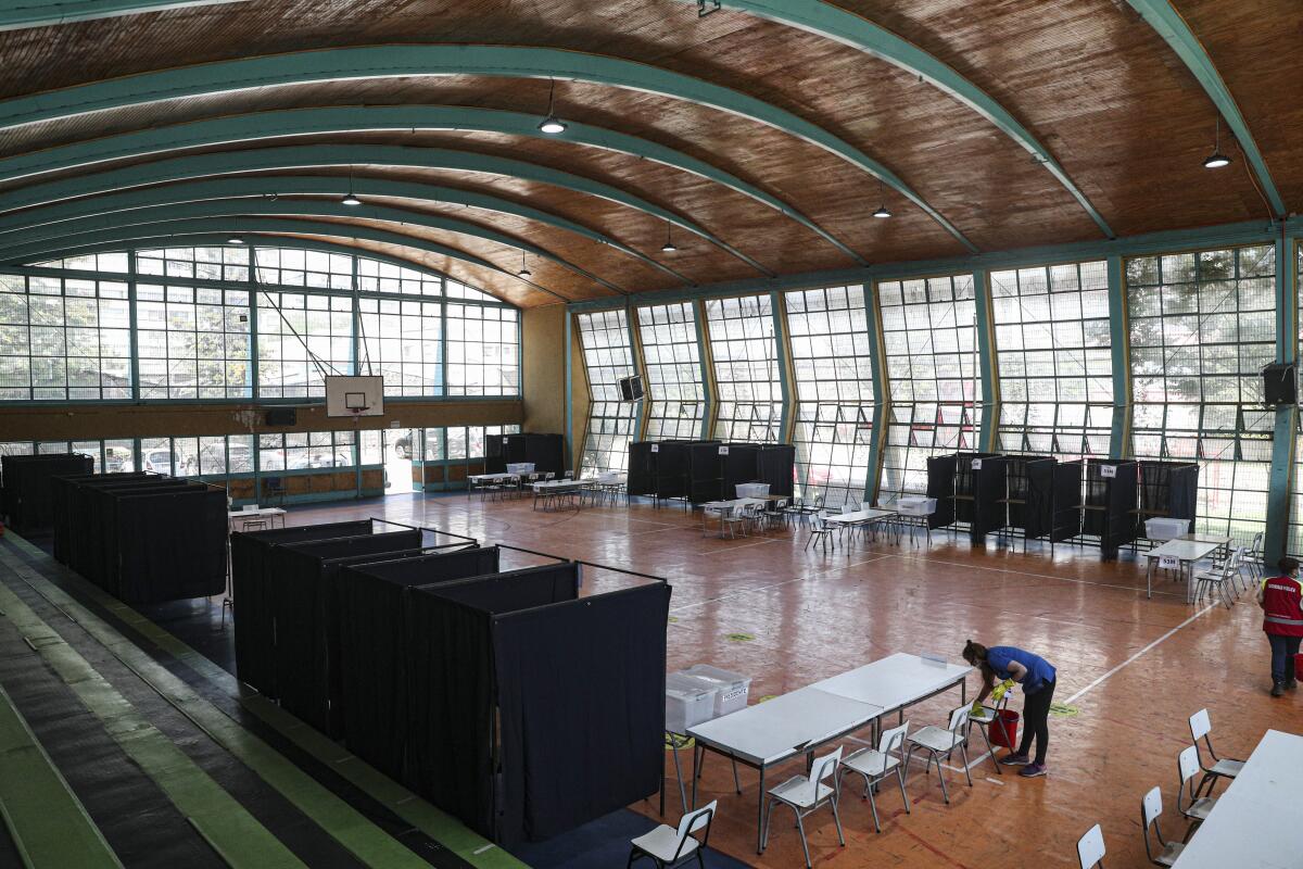 A worker wipes a chair at a gymnasium that will serve as a polling station in Santiago, Chile. 