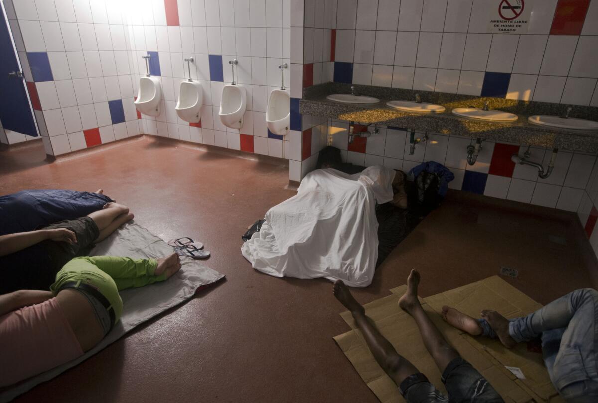 Migrantes cubanos durmen dentro de un baño público del edificio de control fronterizo en Peñas Blancas, Costa Rica, frontera con Nicaragua. (Foto AP/Esteban Félix)