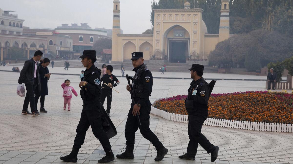 Uighur security personnel patrol near the Id Kah Mosque in Kashgar in western China's Xinjiang region in this 2017 file photo.
