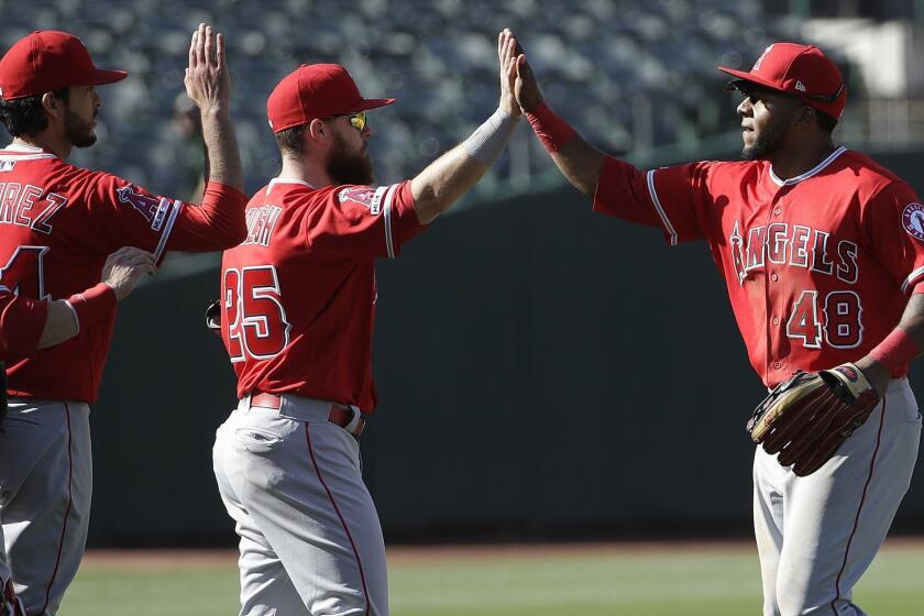 Los Angeles Angels' Cesar Puello, right, celebrates with teammates after a baseball game against the Oakland Athletics in Oakland, Calif., Wednesday, May 29, 2019. (AP Photo/Jeff Chiu)