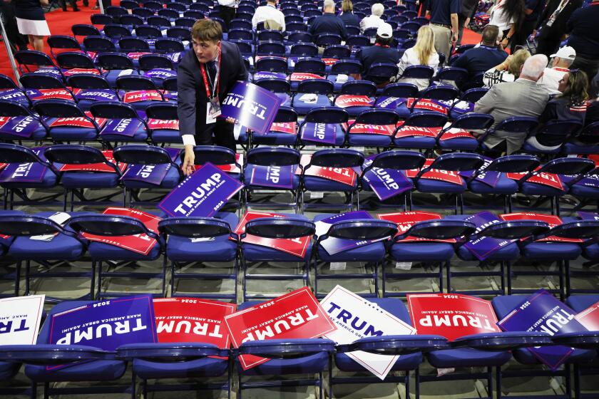 MILWAUKEE, WIS. JULY 15, 2024 - A worker puts out Trump signs during the Republican National Convention Monday, July 15, 2024, in Milwaukee. (Robert Gauthier / Los Angeles Times)
