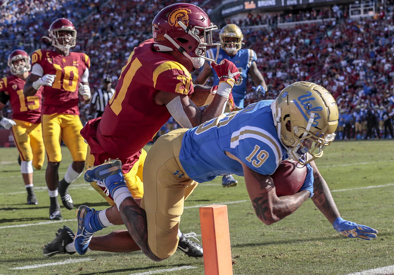 UCLA running back Kazmeir Allen (19) falls short of a touchdown as he is tackled by USC safety Isaiah Pola-Mao (21) during first half action at the Coliseum on Saturday.