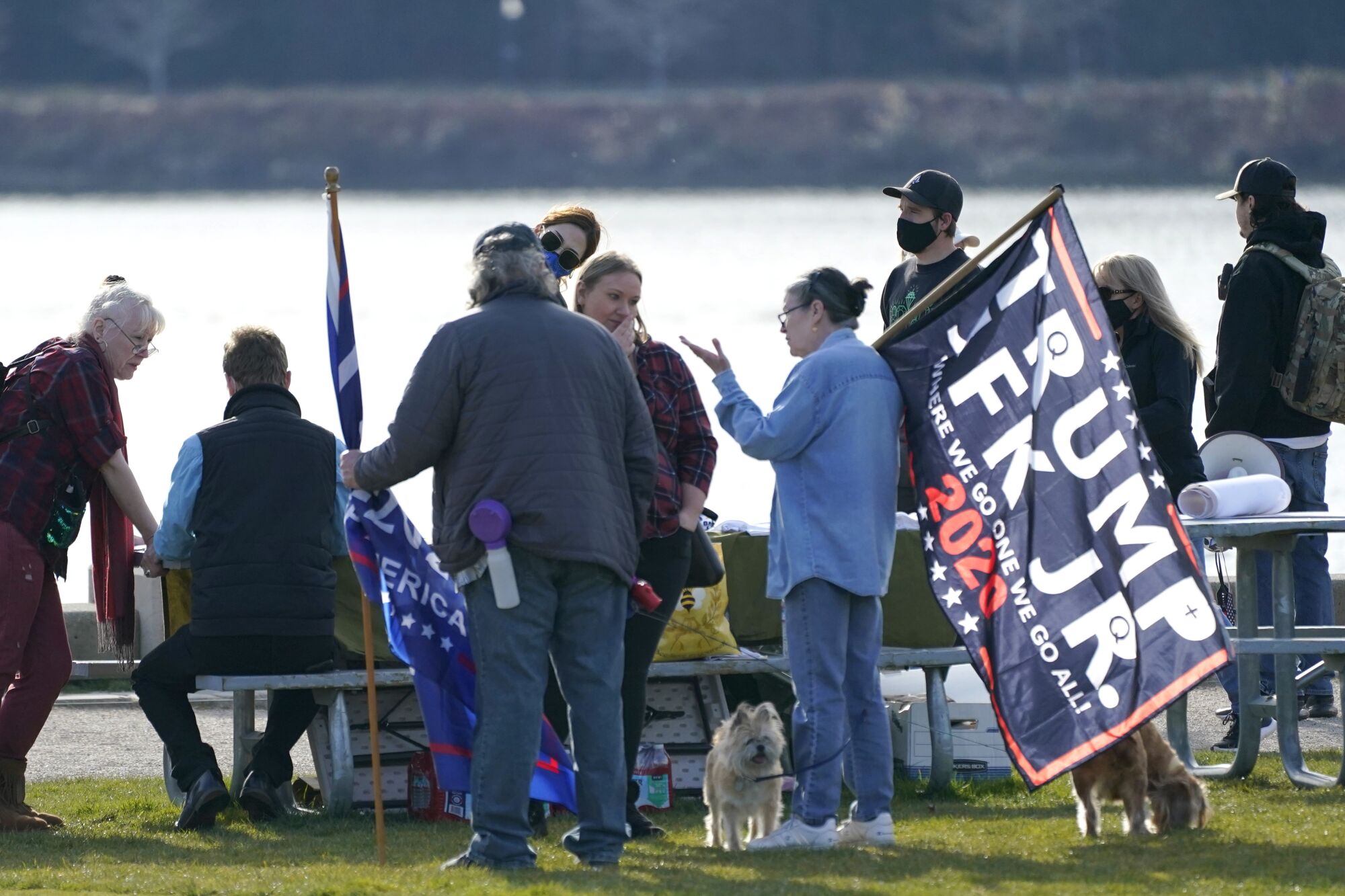 A person holds a flag promoting former President Trump and John F. Kennedy Jr.