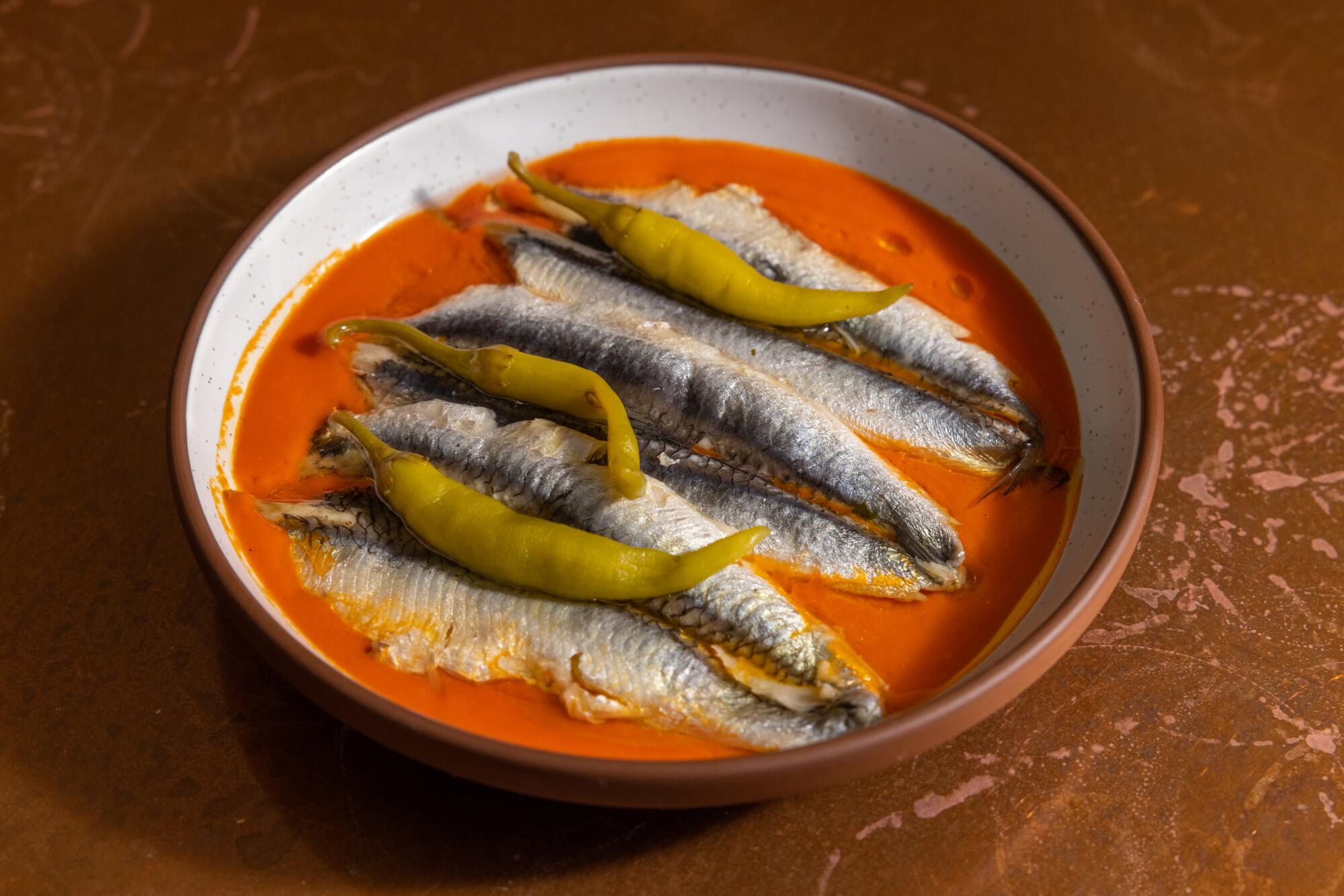 A plate of piquillo peppers with boquerones in an orange sauce 