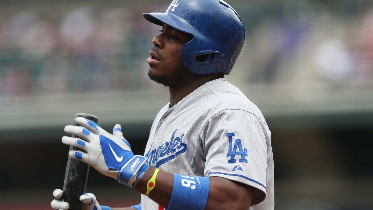 Dodgers' Yasiel Puig reacts after striking out during the first inning of the team's 5-4 loss in 10 innings to the Colorado Rockies on Saturday. Puig suffered a left hip flexor in the loss.