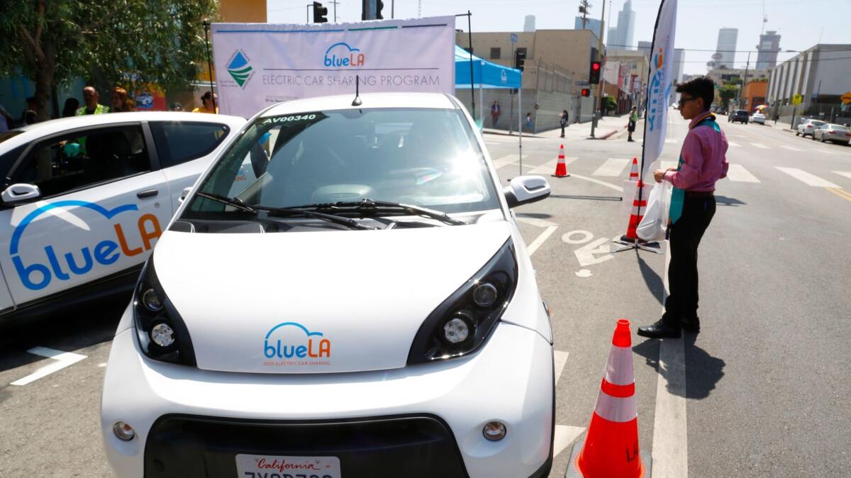One of the BlueLA cars in the new ride-sharing program is parked on 7th Street during a news conference.