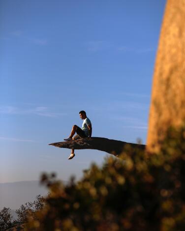 A hiker takes in the view from Potato Chip Rock in Ramona.