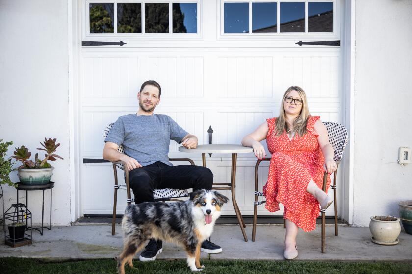 Los Angeles, CA - March 23: Becca and Jon Rutledge, with their Australian Shepard Boomer, evacuated from their Malibu Airbnb rental days before their wedding during the 2018 Woolsey fire, and are photographed in the backyard of their Westchester neighborhood home in Los Angeles, CA, Wednesday, March 23, 2022. The couple were woken up in the middle of the night by the property owner and told they needed to evacuate. The rental and wedding sites both burned in the Woolsey fire and the Rutledges moved their wedding to the Palos Verdes Penninsula. (Jay L. Clendenin / Los Angeles Times)