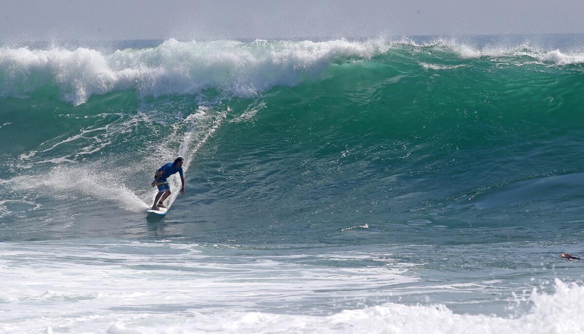A surfer navigates a big wave generated from an outer reef over the weekend in Laguna Beach.
