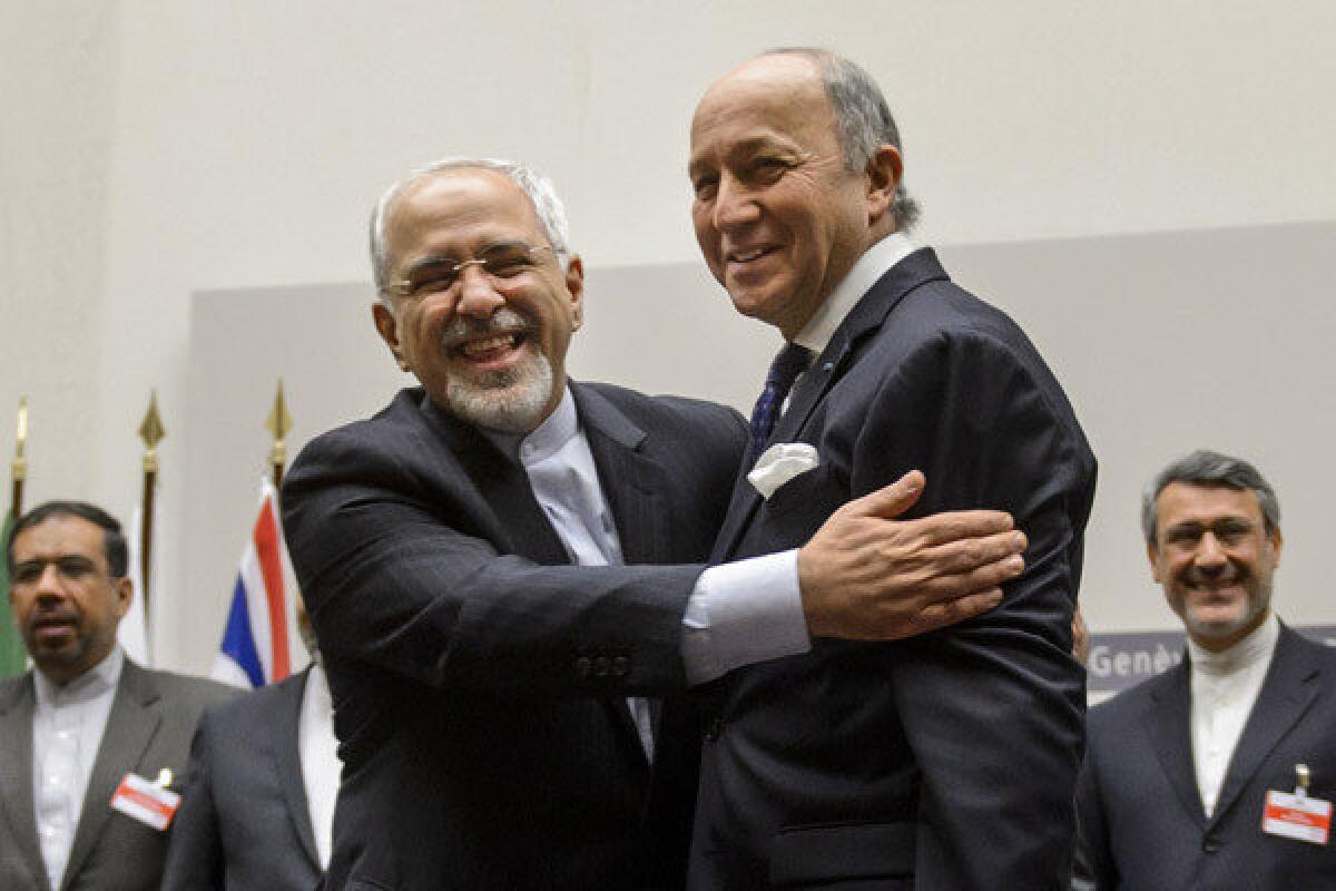 Iranian Foreign Minister Mohammad Javad Zarif, left, and French Foreign Minister Laurent Fabius embrace after a landmark deal to limit Iran's nuclear program is announced.