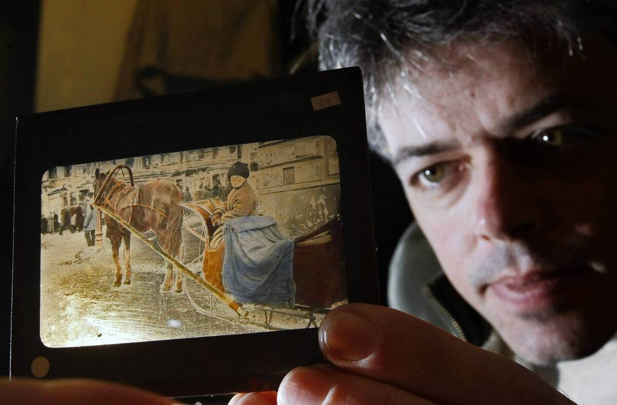 Anton Orlov holds a 1917 "magic lantern" slide from Russia, part of a treasure trove of images he obtained from the grandaughter of a man who took them during the revolution.