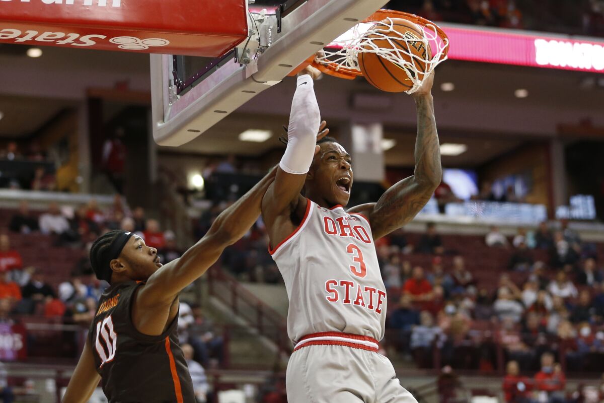 Ohio State's Eugene Brown, right, dunks as Bowling Green's Cam Young defends during the second half of an NCAA college basketball game Monday, Nov. 15, 2021, in Columbus, Ohio. (AP Photo/Jay LaPrete)