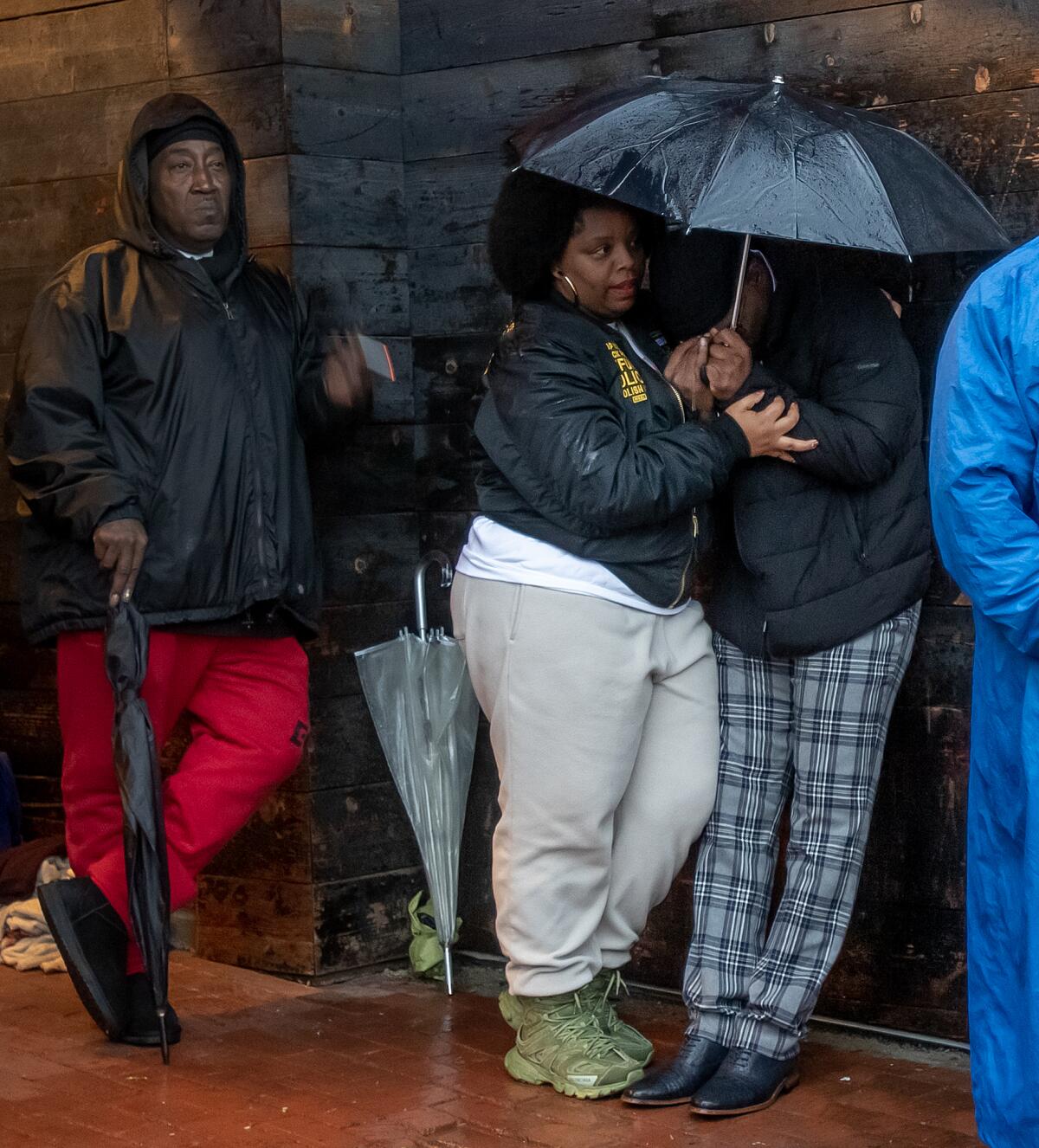 Patrisse Cullors and other relatives hold umbrellas at a candlelight vigil for Keenan Anderson.