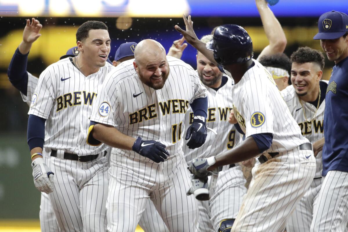 Milwaukee Brewers' Rowdy Tellez (11) celebrates with teammates after driving in the winning run with a single during the 10th inning of the team's baseball game against the San Francisco Giants on Friday, Aug. 6, 2021, in Milwaukee. (AP Photo/Aaron Gash)