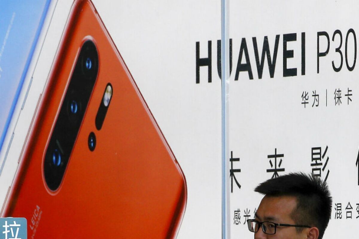 A staffer looks out from a Huawei retail store in Beijing.