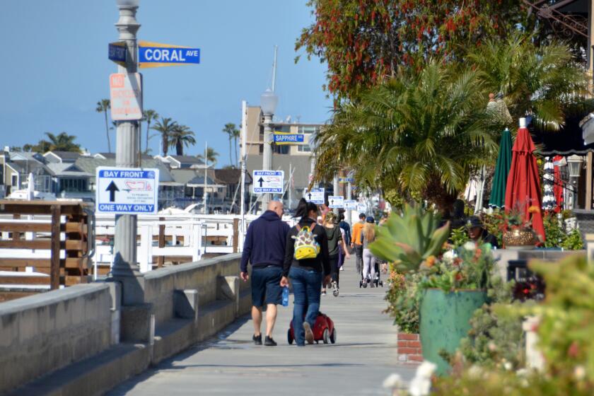 Groups of people obeying the "one-way" directional signs, make their way around Balboa Island Saturday morning.