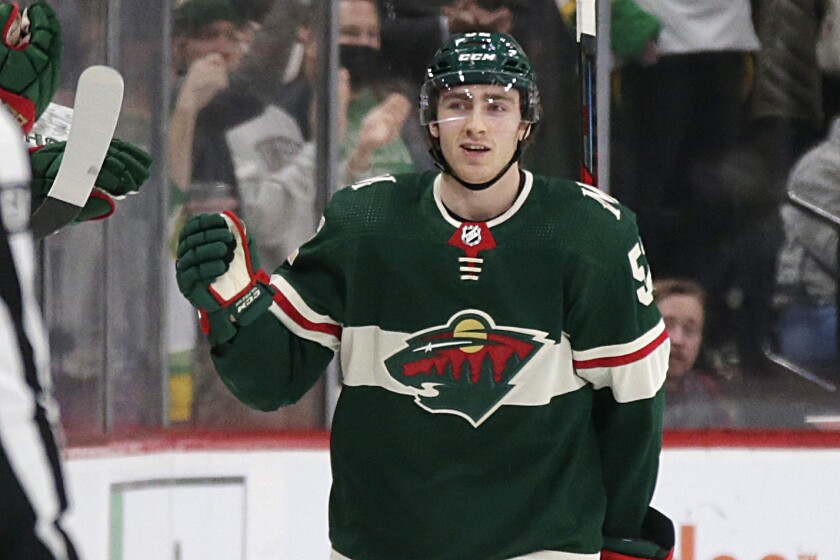 Minnesota Wild center Connor Dewar is congratulated by teammates after scoring his first career goal against the Montreal Canadiens in the second period of an NHL hockey game Monday, Jan. 24, 2022, in St. Paul, Minn. (AP Photo/Andy Clayton-King)