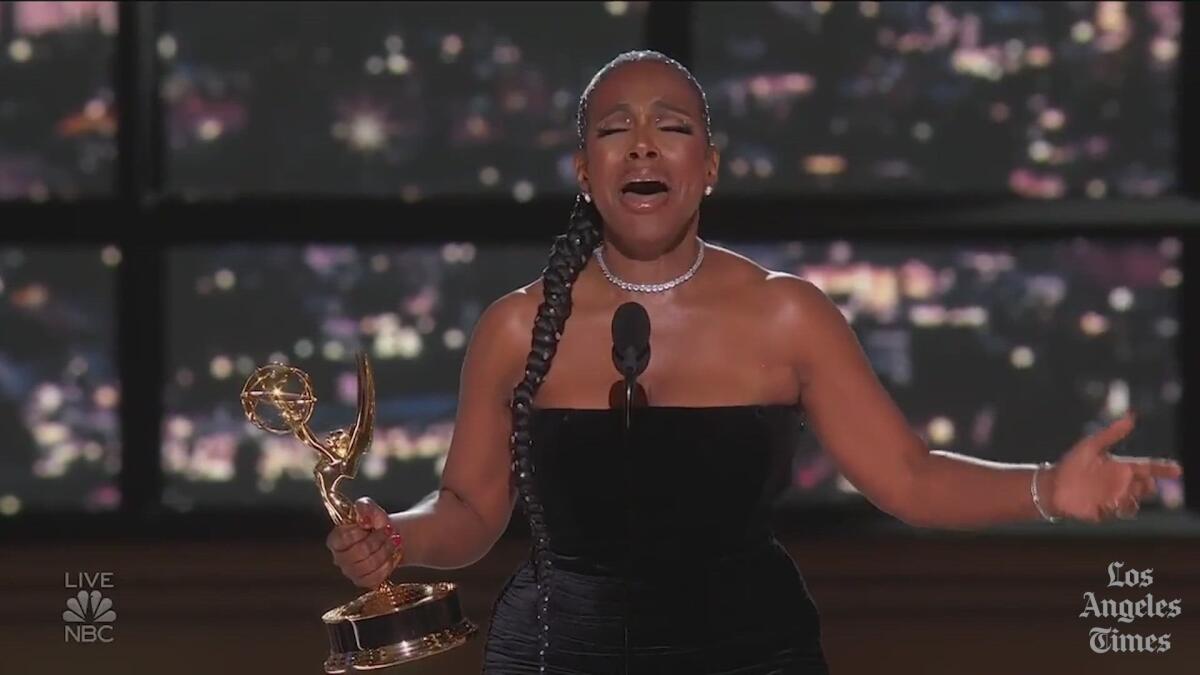 A woman holding an emmy breaks out in song 