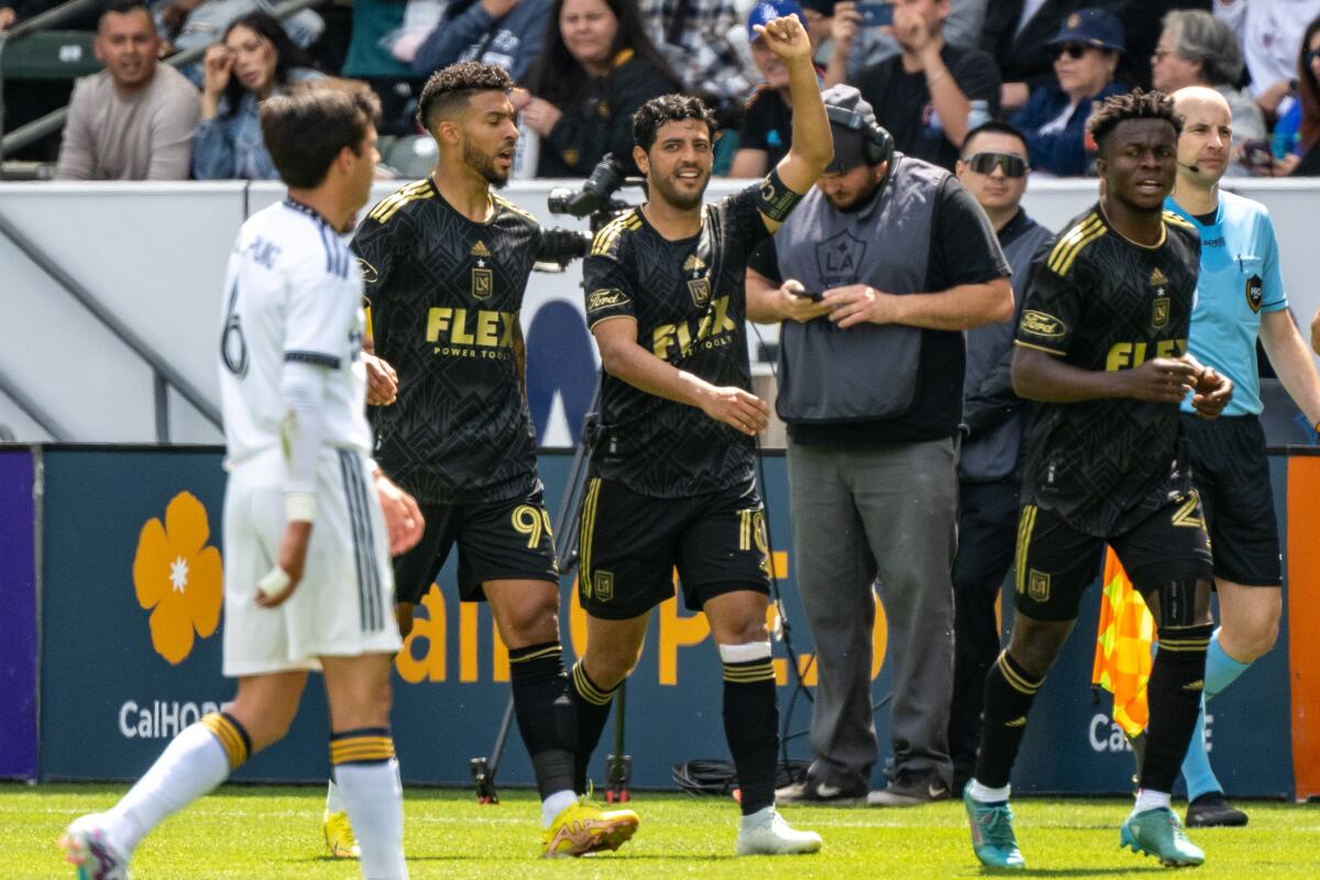 Carlos Vela raises his arm as he celebrates after scoring the first of his two goals Sunday in LAFC's win over the Galaxy.