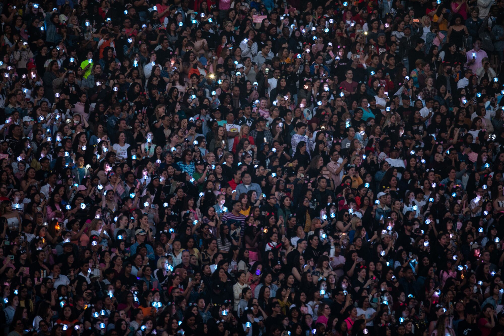 A mass of people holding up lighted phones.