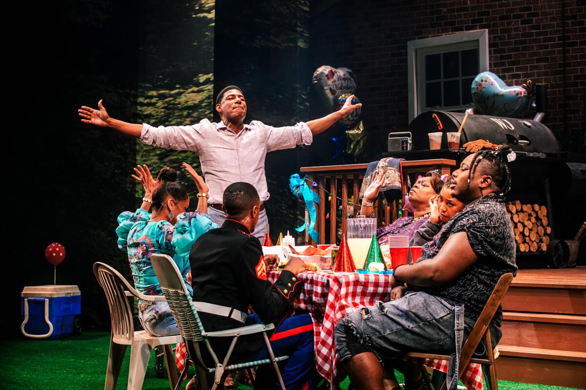 Characters are gathered around a picnic table in "Fat Ham" at the Geffen Playhouse.