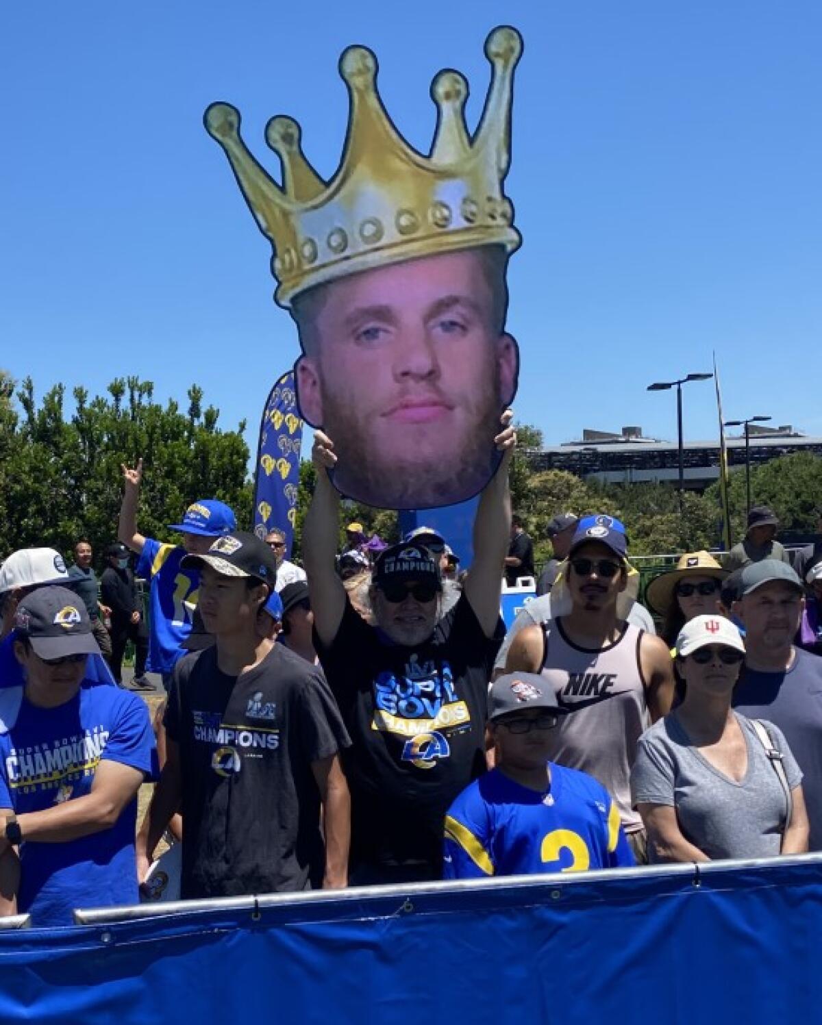 Rams fan Robert Gonzalez holds up a Cooper Kupp cutout adorned with a crown.