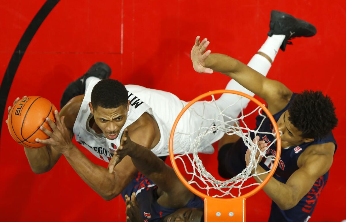 San Diego State's Matt Mitchell, left, goes up for a shot against Fresno State defenders on Jan. 1, 2020.