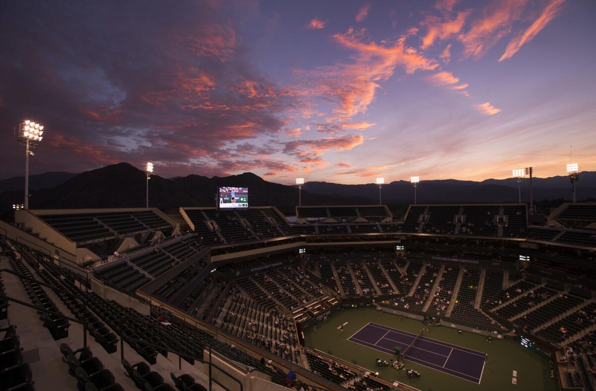 The sun sets behind the mountains as Federico Delbonis of Argentina plays American Ryan Harrison in the first round at the BNP Paribas Open at Indian Wells Tennis Garden in Indian Wells.