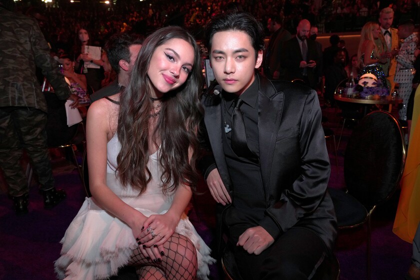 A woman and man smile and pose together while seated.