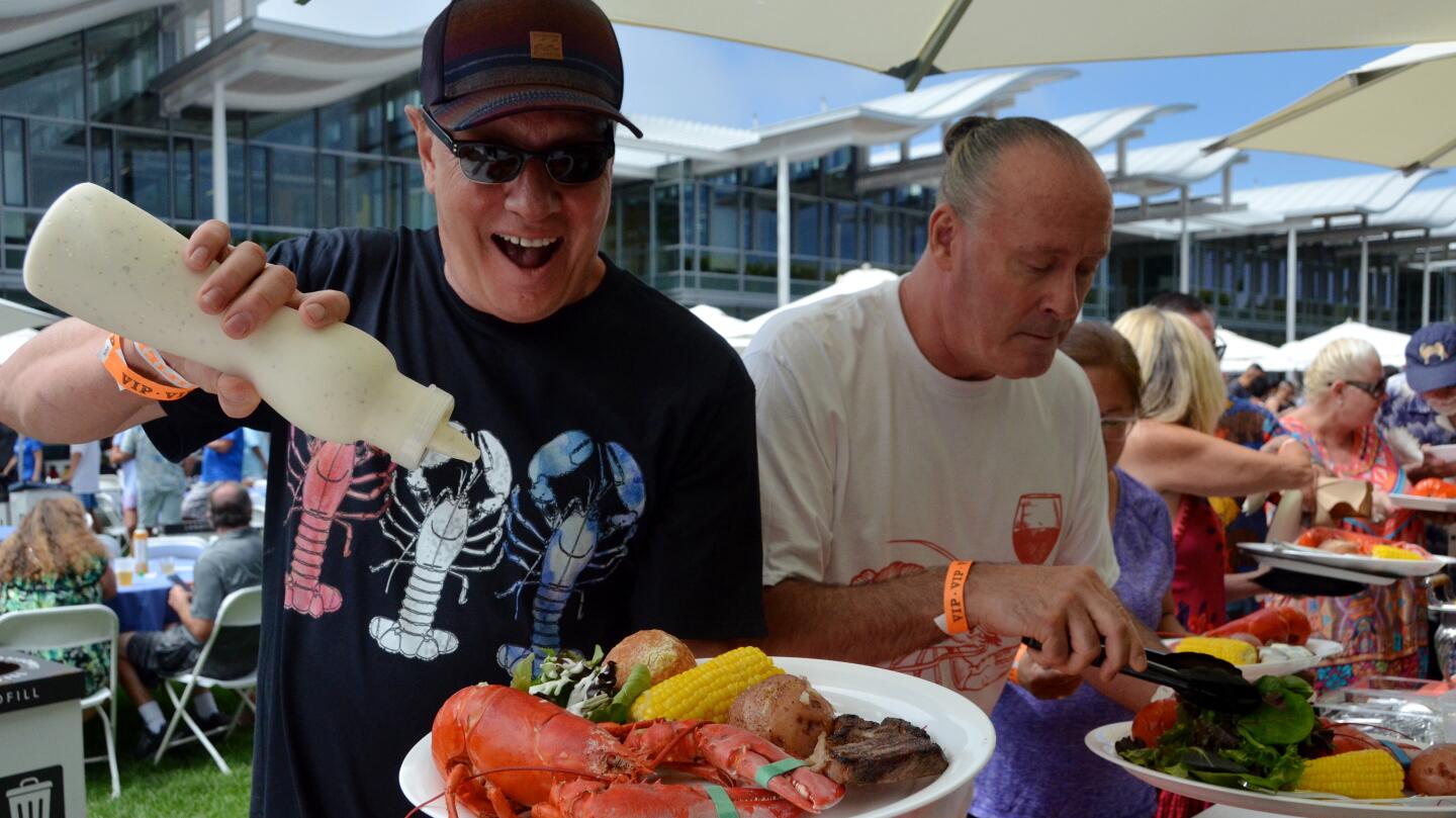 Food critic Tony Reverditto squirts dressing on his salad during Lobsterfest on Sunday at the Newport Beach Civic Center green.