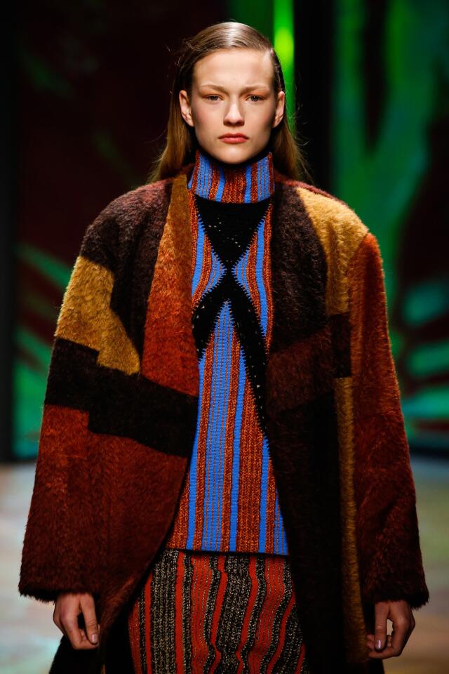 A model wears a wool coat over a striped skirt and shirt at Thakoon Panichgul's runway show.