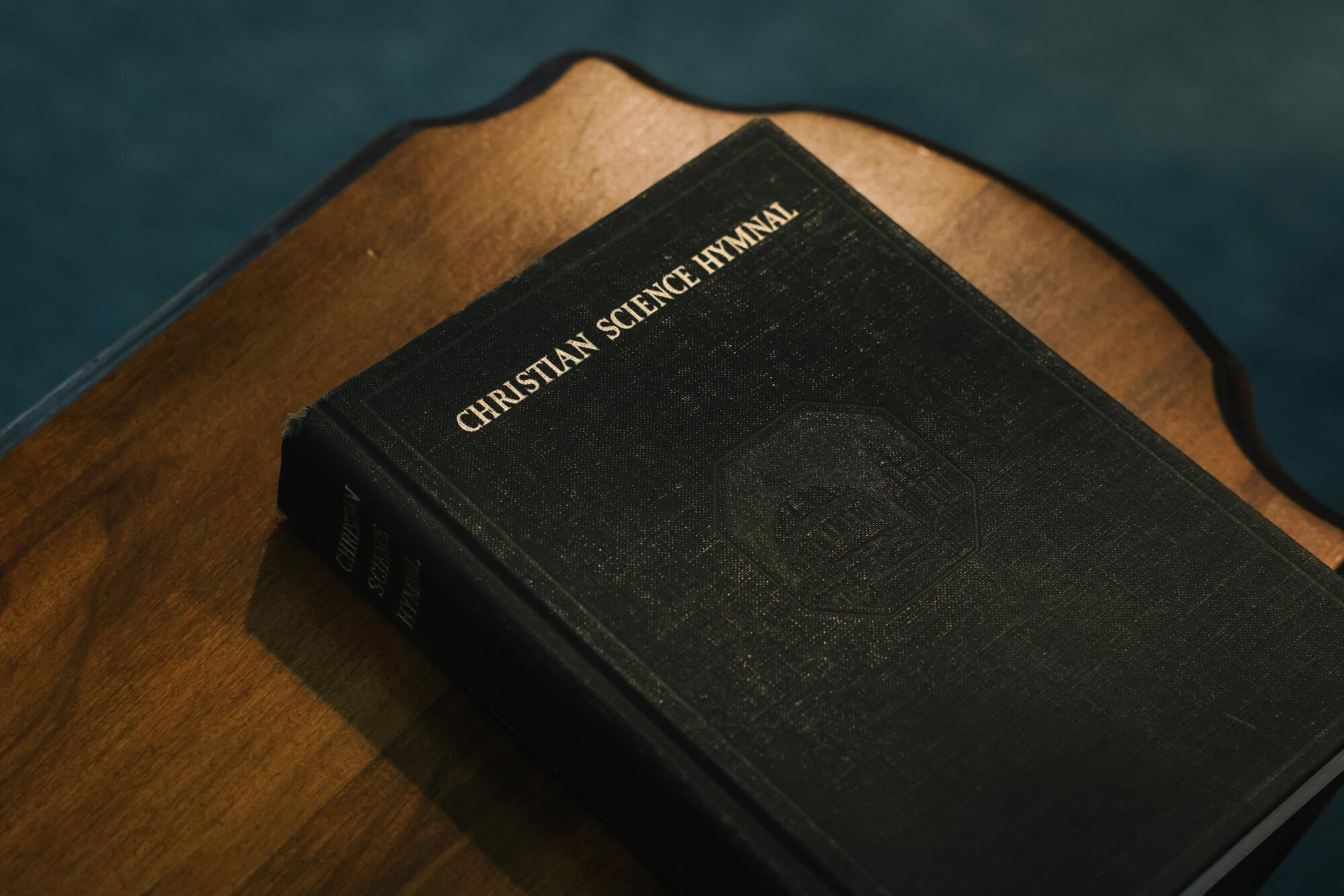 A Christian Science Hymnal book sits on a table during a service.