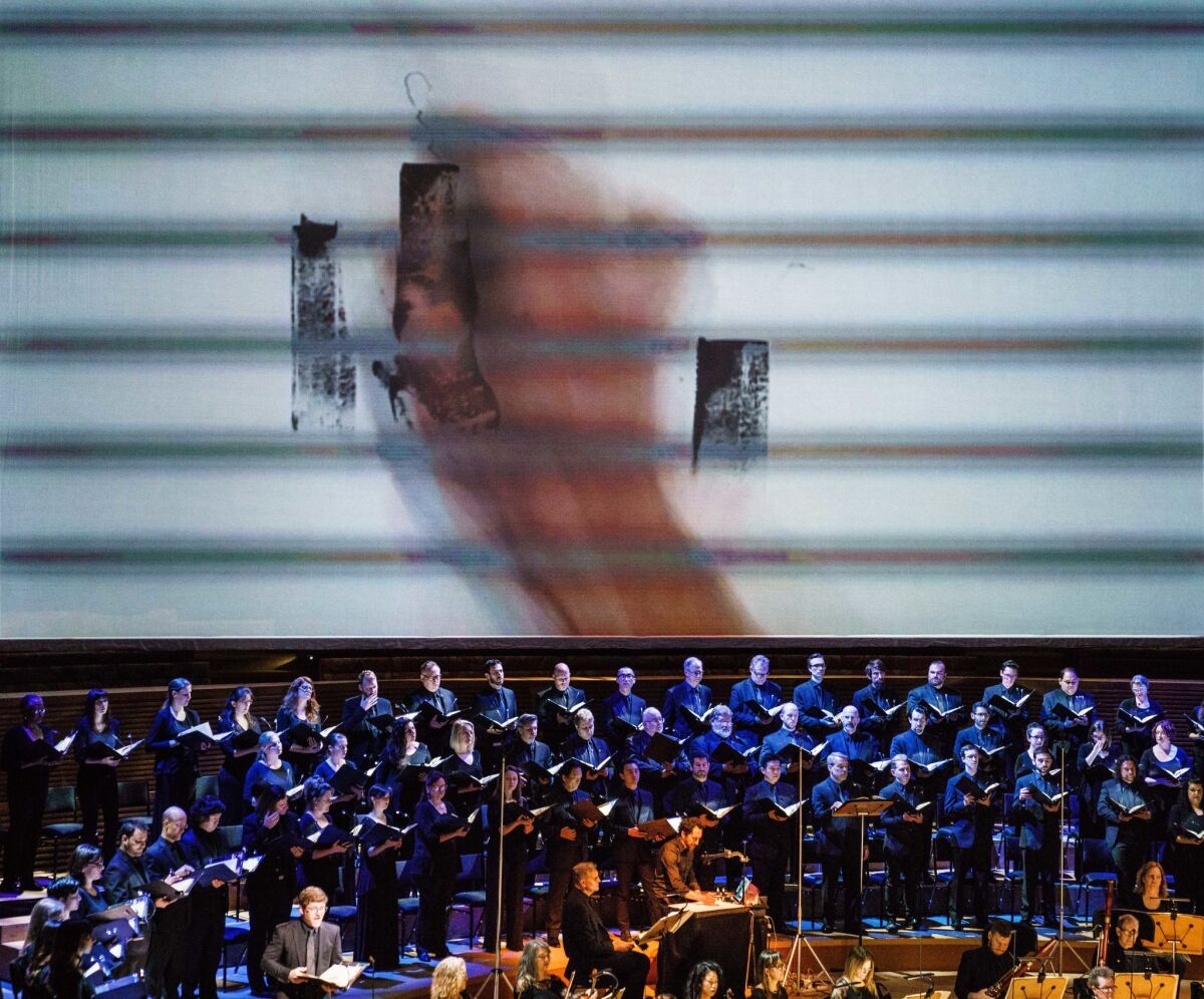 Kevork Mourad's hand appears on screen as he draws live to the Master Chorale's singing of Handel on Sunday.