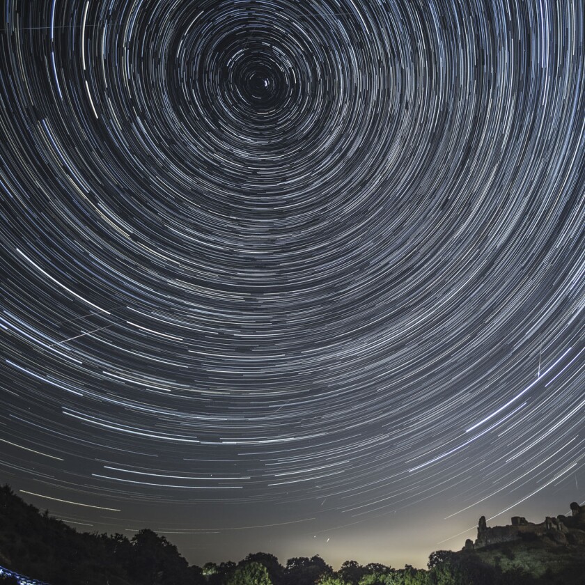 Composite image of satellites, planes and comets in transit across the night sky.