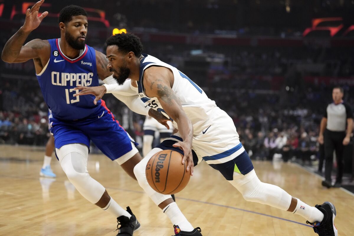 Timberwolves guard Mike Conley drives in front of Clippers forward Paul George 