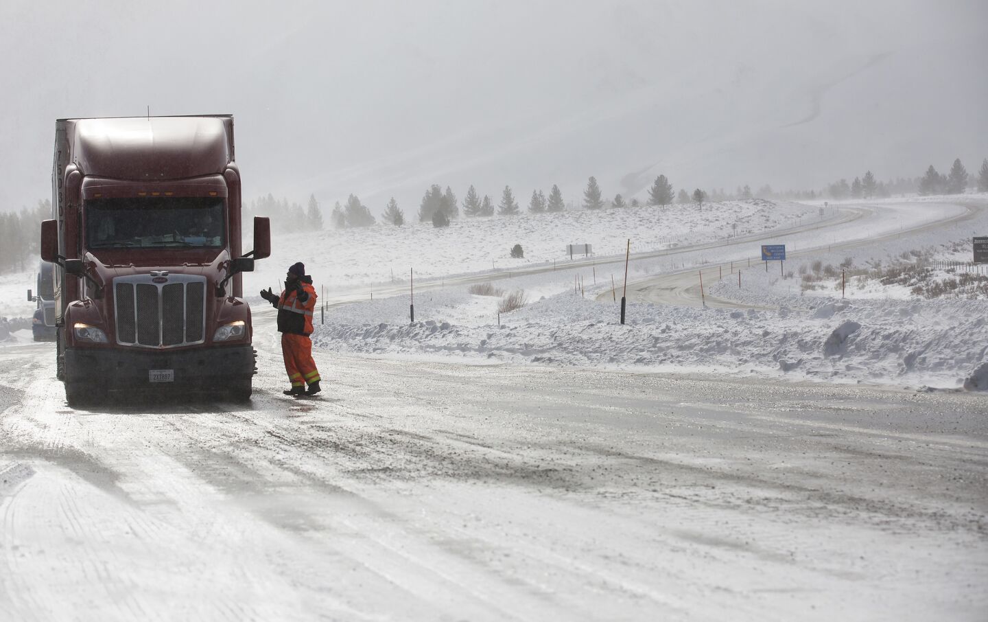 Caltrans worker Mark Reistetter tells a Reno-bound truck driver his options at a checkpoint closing all northbound traffic at U.S. 395 and State Route 203 near Mammoth Lakes.