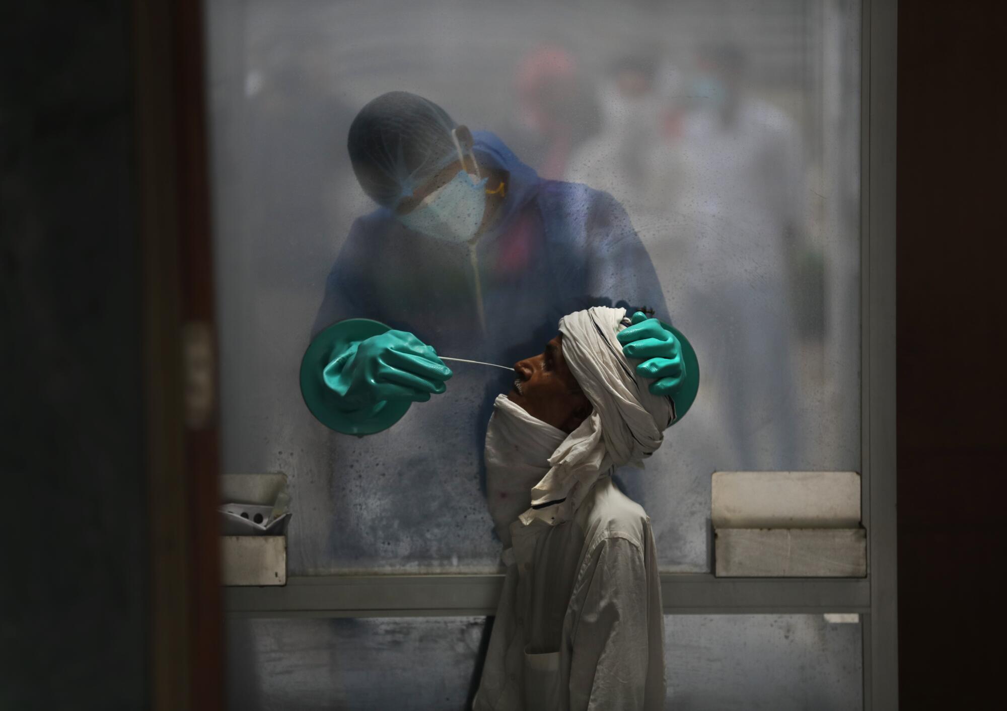 A health worker takes a nasal swab