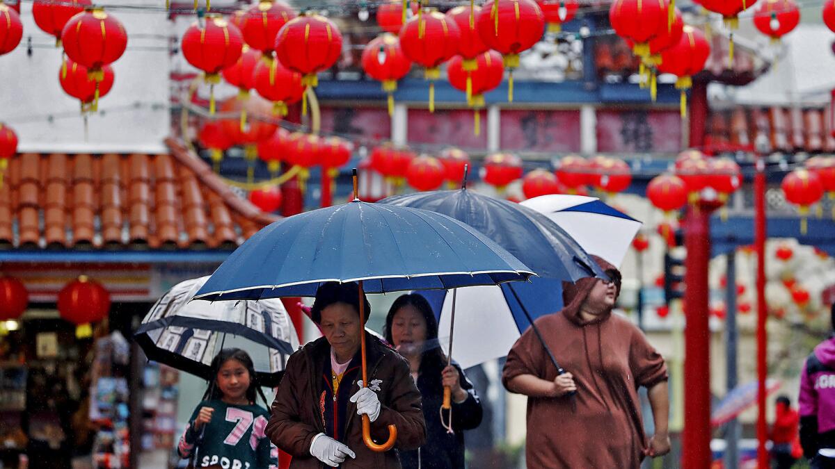 Visitors to Old Chinatown walk in the rain on Saturday, Mar. 2, 2019.