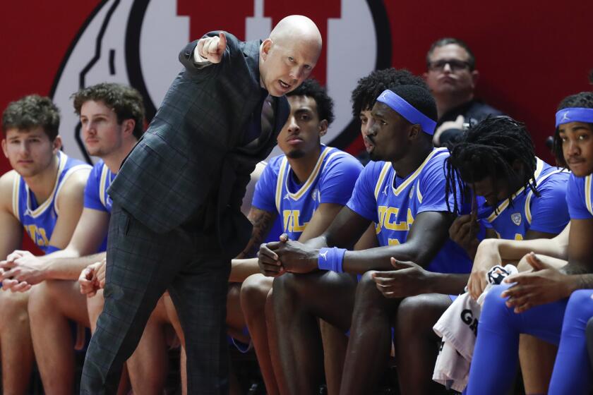 UCLA coach Mick Cronin talks to players on the bench during a game at Utah