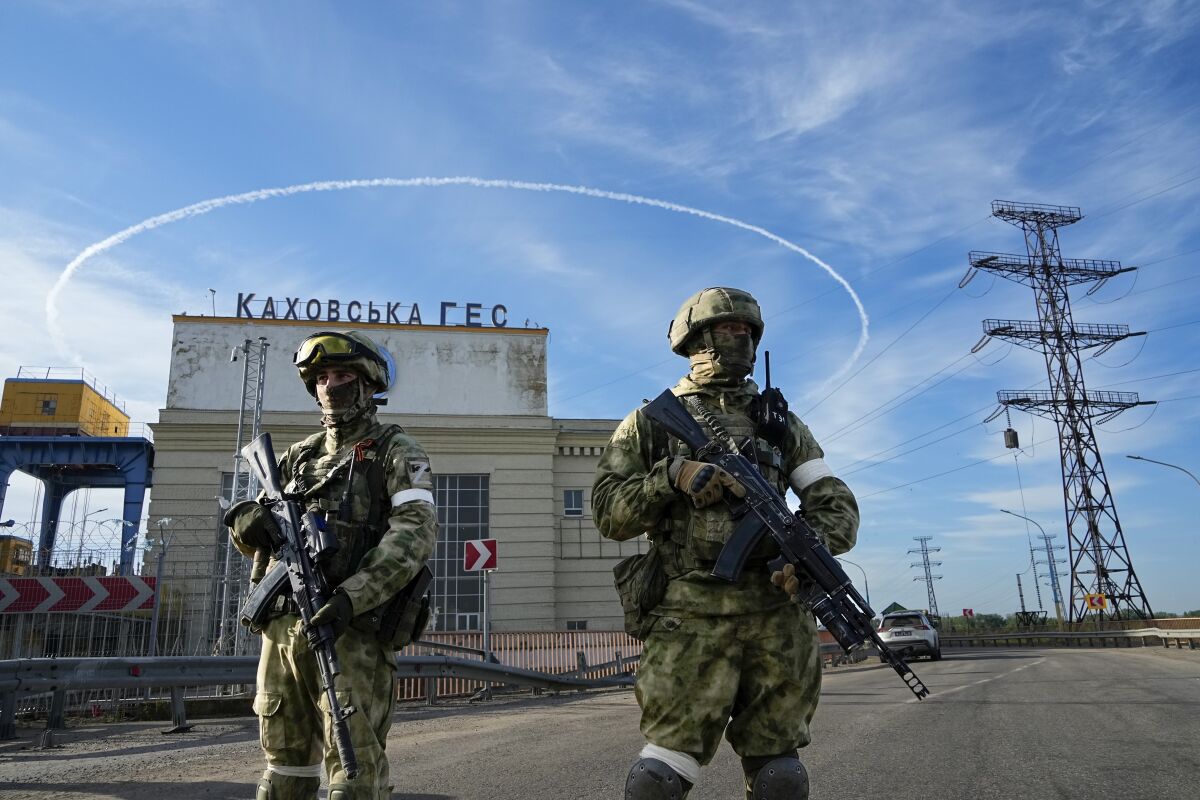 ARCHIVO - Soldados rusos vigilan la entrada de la Central Eléctrica de Kakhovka, en el río Dniéper, 