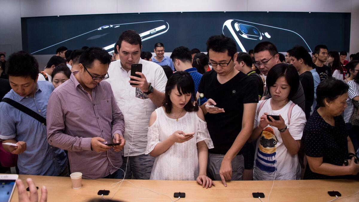 Chinese customers test the new iPhone 7 during the opening of sales at an Apple store in Shanghai on Sept. 16, 2016.