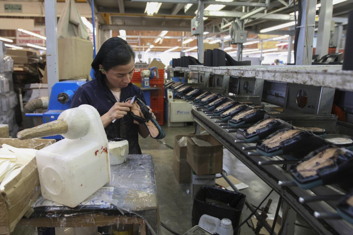 ARCHIVO - Una mujer trabaja en una maquiladora de calzado en León, México, el 7 de febrero de 2023.