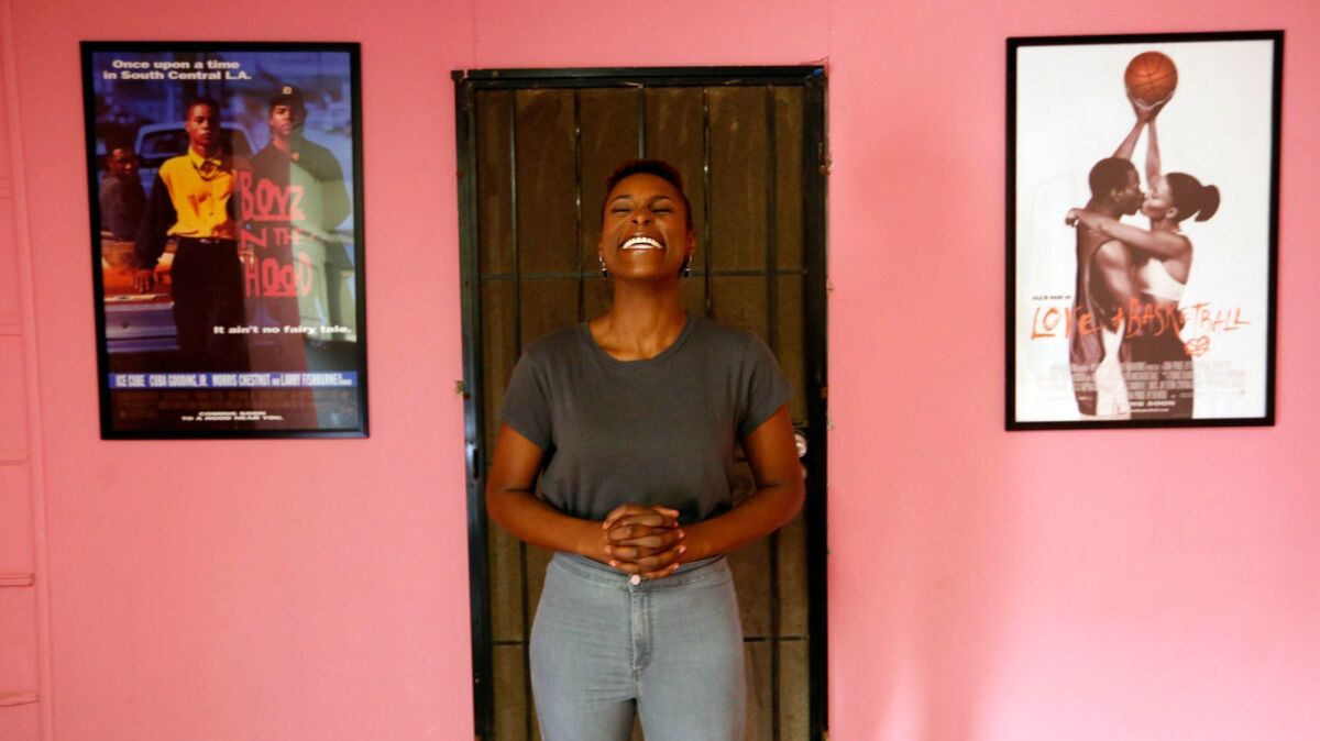 Actress Issa Rae enjoys a light moment between the movie posters for, "Boyz N the Hood," and "Love and Basketball," at her office in Inglewood.