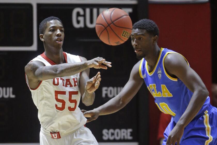 Utah guard Delon Wright passes the ball in front of UCLA guard Isaac Hamilton during the first half of a game on Jan. 4 in Salt Lake City. The Utes beat the Bruins, 71-39.