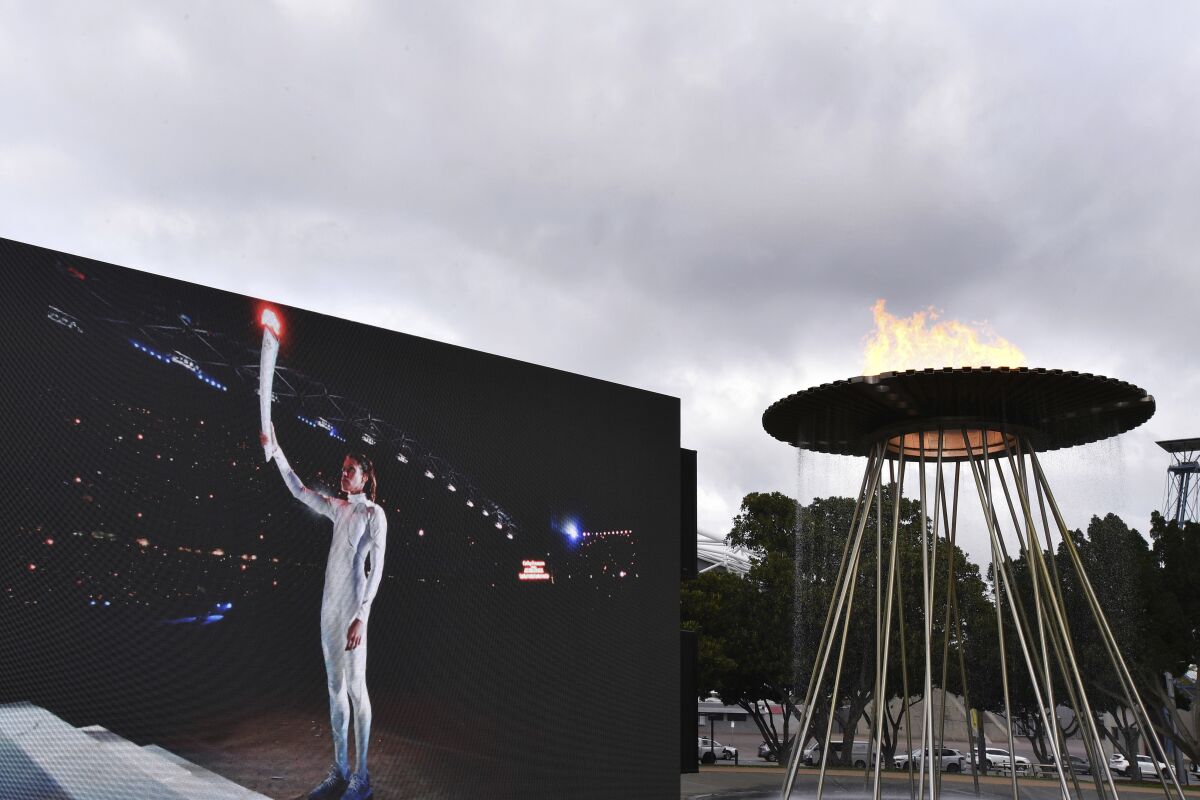 A video screen shows Cathy Freeman lighting the Olympic Cauldron as part of the 20th anniversary celebrations of the Sydney 2000 Olympic Games in Sydney, Tuesday, Sept. 15, 2020. Freeman, who lit the cauldron at the original opening ceremony and won the 400-meter race at the track in one of the country's all-time great sporting moments, said it was a wonderful gesture to have "two future stars" recognized on such a major stage ahead of the rescheduled 2020 Games in Tokyo next year. (Dean Lewins/AAP Image via AP)