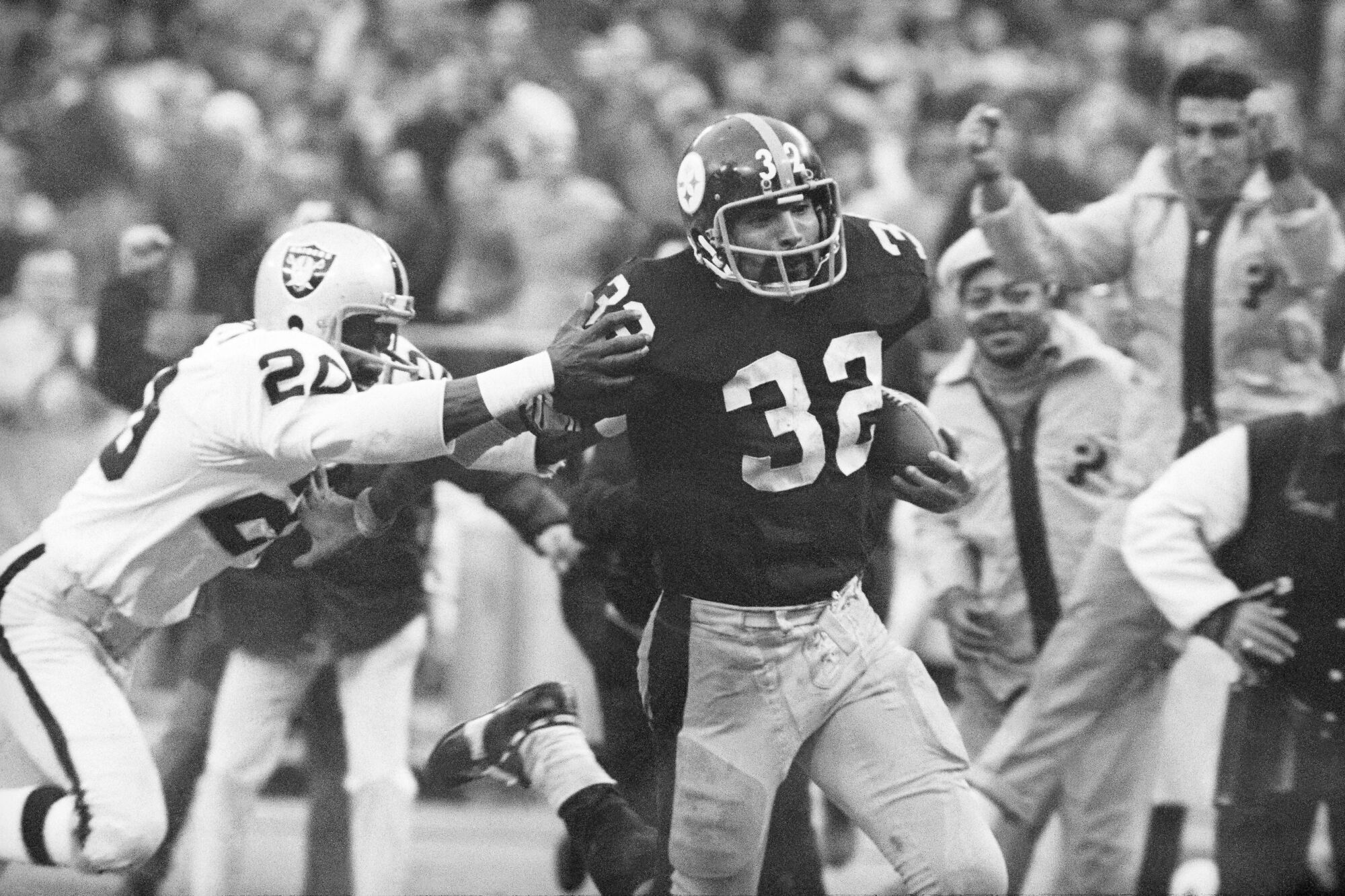 The Steelers' Franco Harris eludes the Raiders' Jimmy Warren as he runs after the "Immaculate Reception." 